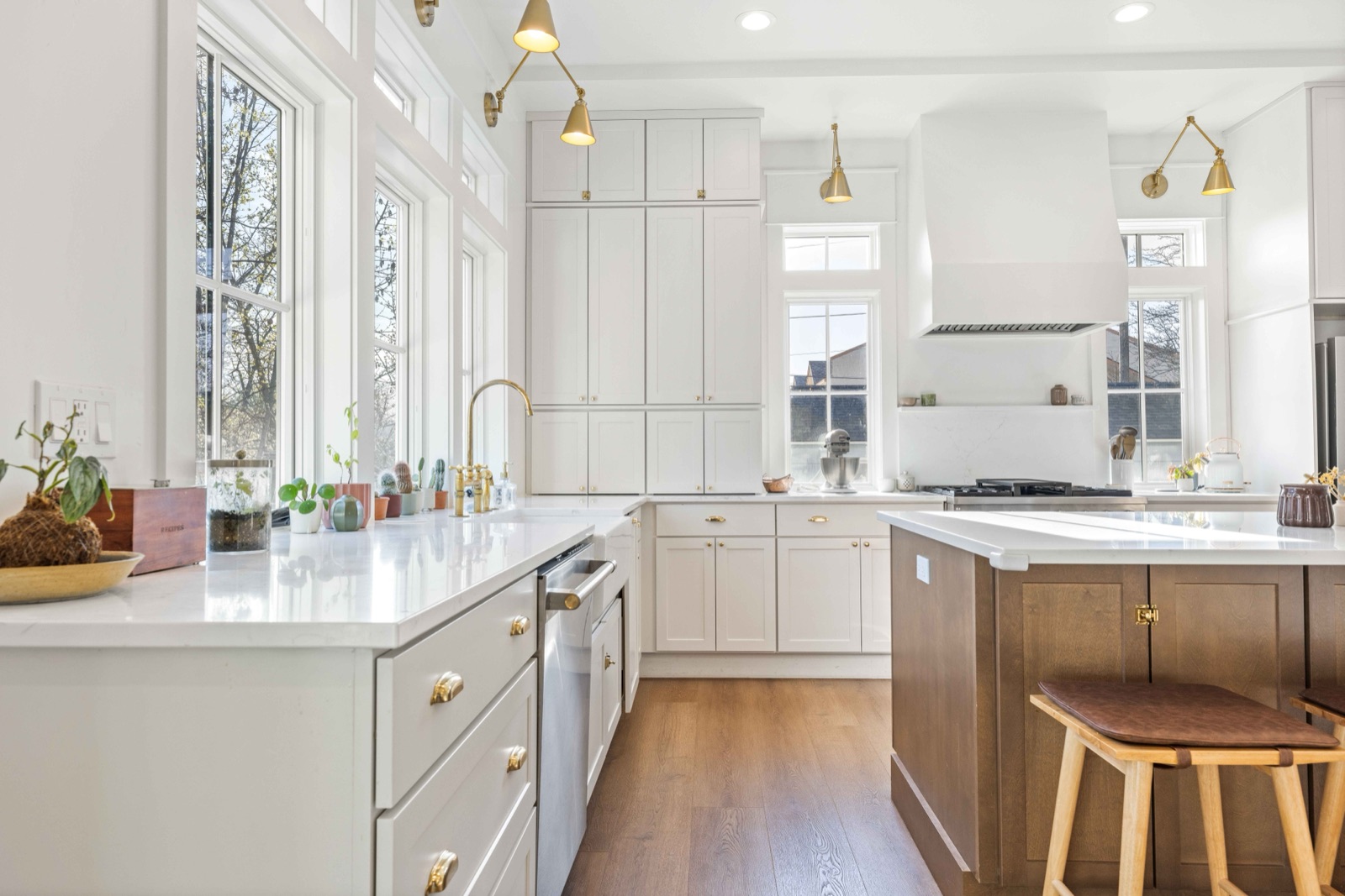 Bright remodeled kitchen with white cabinetry, brass fixtures, and a warm wood island